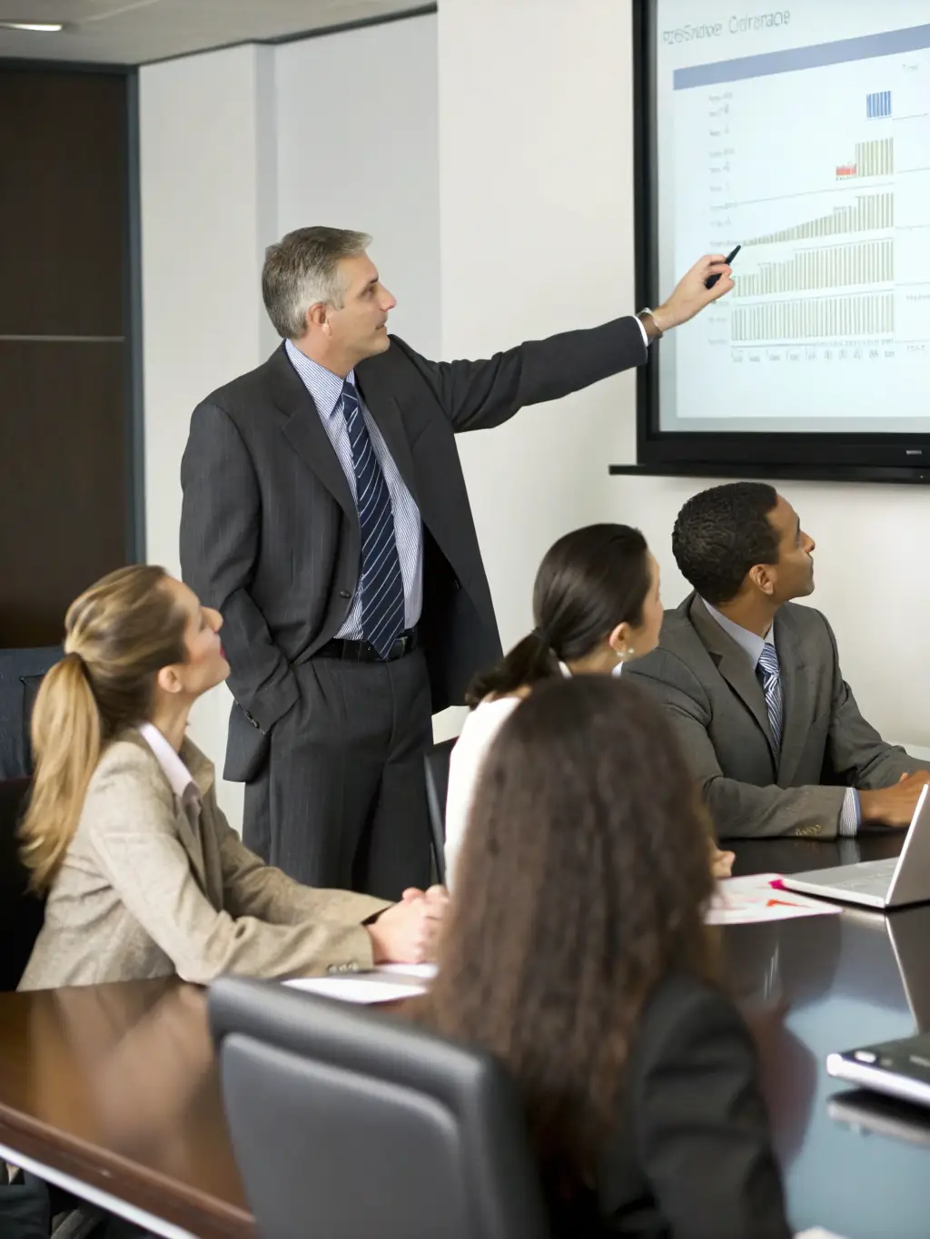 A consultant presenting strategic plans to a team in a modern conference room, symbolizing strategic business support for automotive companies.